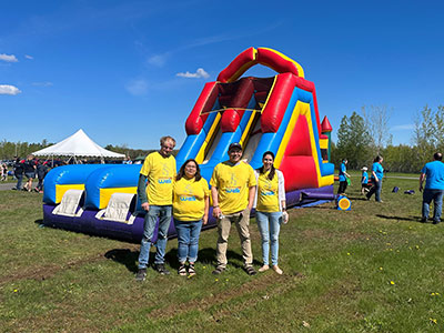 Four People Standing in Front of a Bouncy Slide