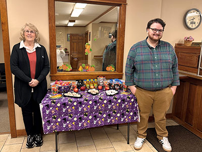 Carol and Dylan standing next to a Halloween decorated table