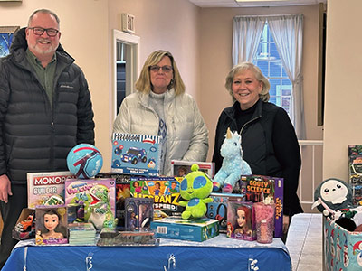 Three people with table of toys