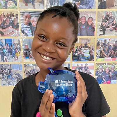 Young Child Holding a Piggy Bank